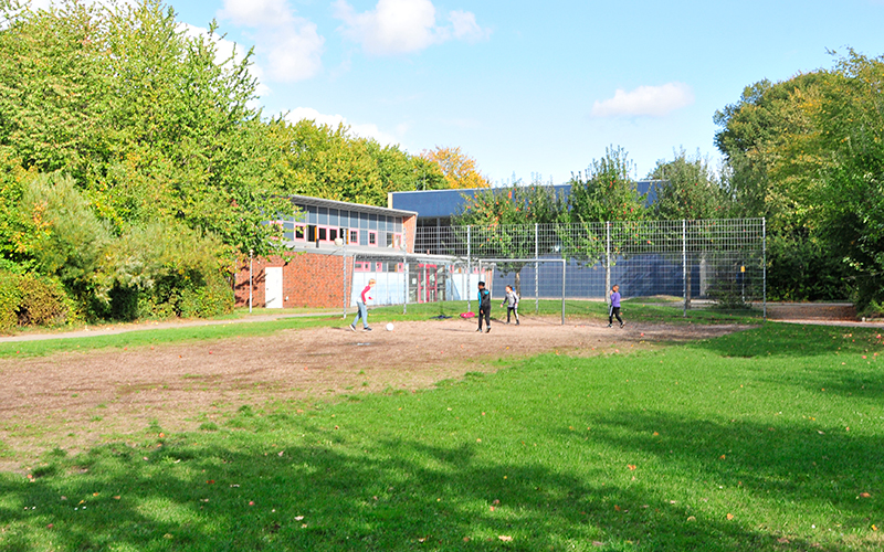 Kinder spielen Fußball auf dem Gelände der Schule Röthmoorweg